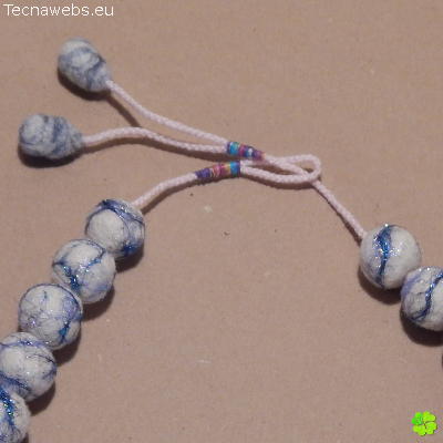 detalle broche collar perlado de lana afieltrada con vetas azules
